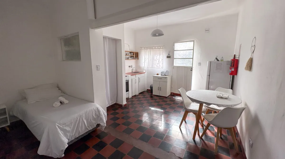 The open space: kitchen, table and the single bed